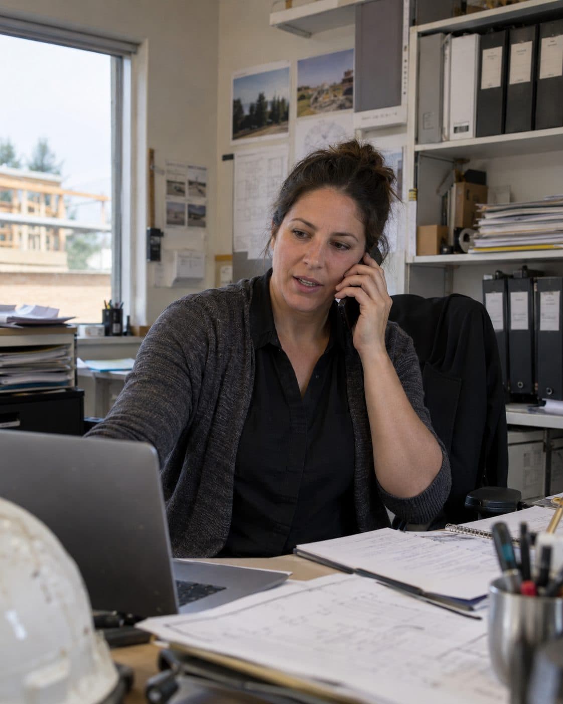 A construction business owner on the phone at her desk.